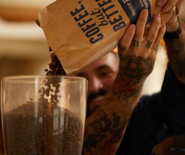 Ethically sourced coffee from Extract Coffee, made by our expert baristas. The bag has the words 'Coffee But Better' in blue written upon it